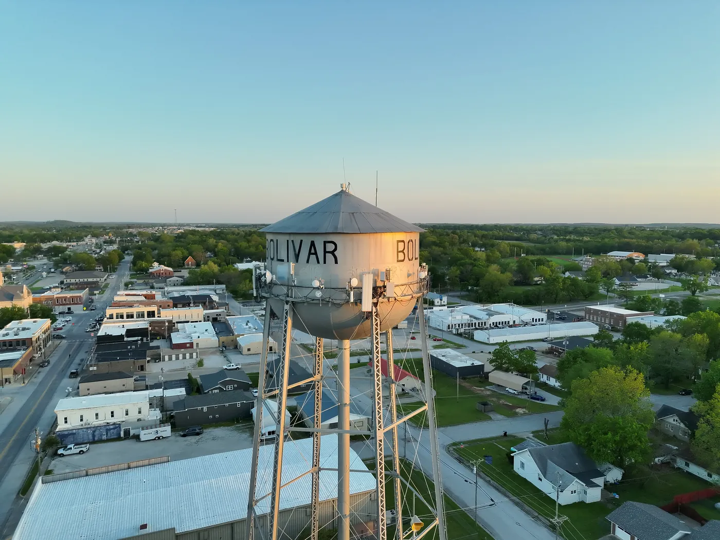 Golden-hour aerial view of the Bolivar water tower above downtown Bolivar, Missouri.