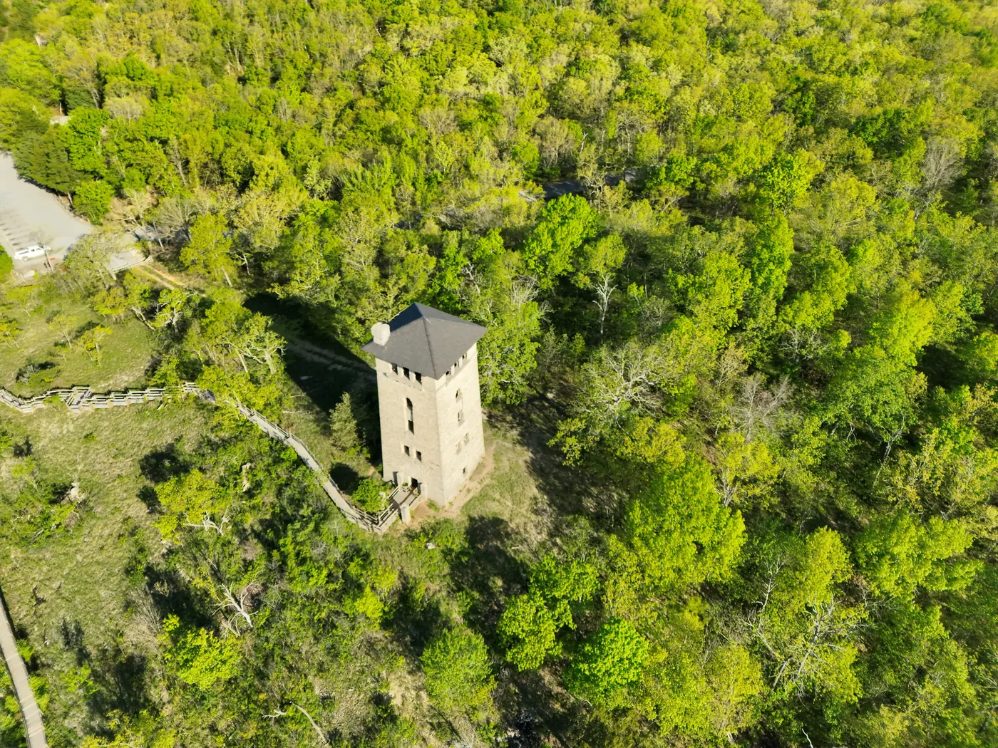 Morning aerial view of a tower at Ha Ha Tonka State Park surrounded by bright green trees.