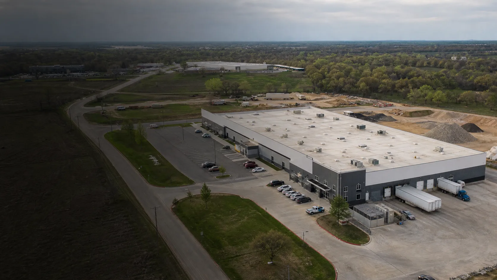 Illustrative aerial view of a commercial property with roof, access, loading, earthwork, and material areas that can affect drone project scope.