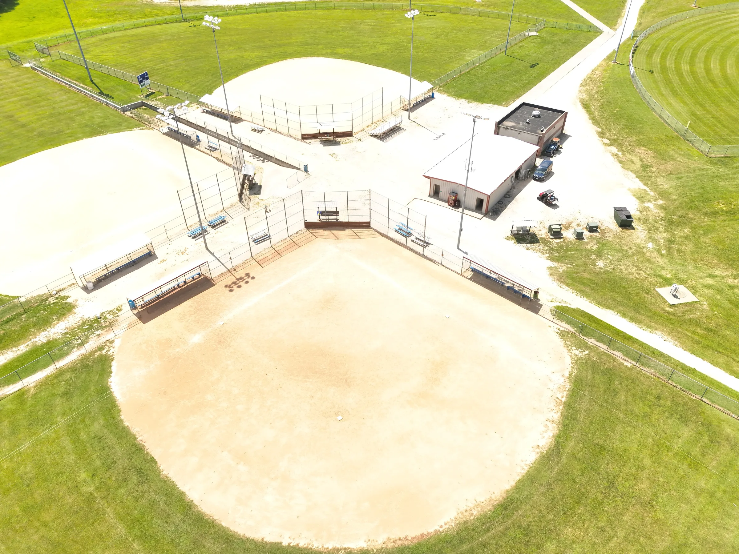 Oblique aerial view looking down across connected ball fields and their central support buildings at Fullerton Ball Fields.