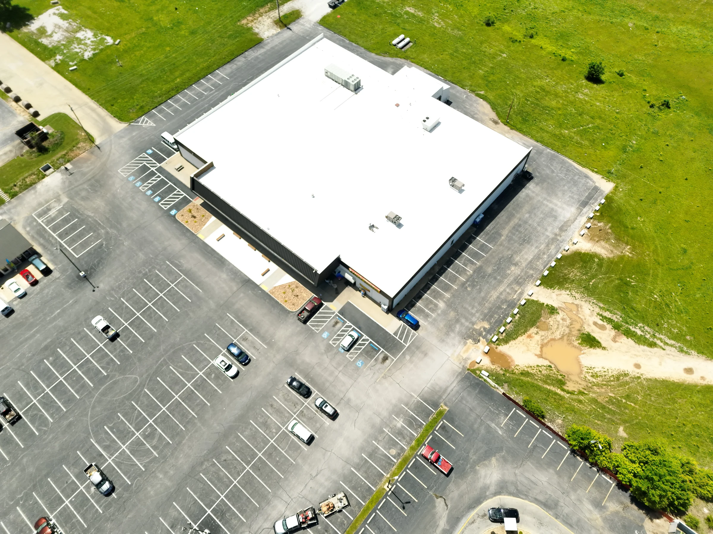 Oblique aerial view of The Hill Church building, roof, parking area, and surrounding property in Bolivar, Missouri.
