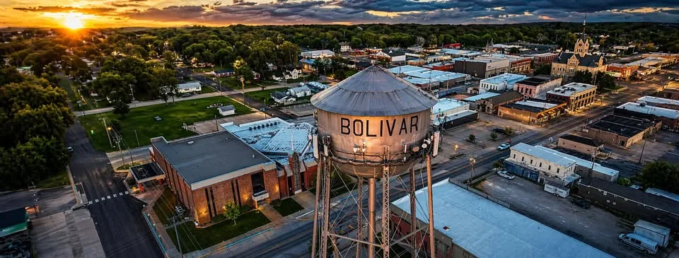 Golden-hour aerial view of the Bolivar water tower above downtown Bolivar, Missouri.